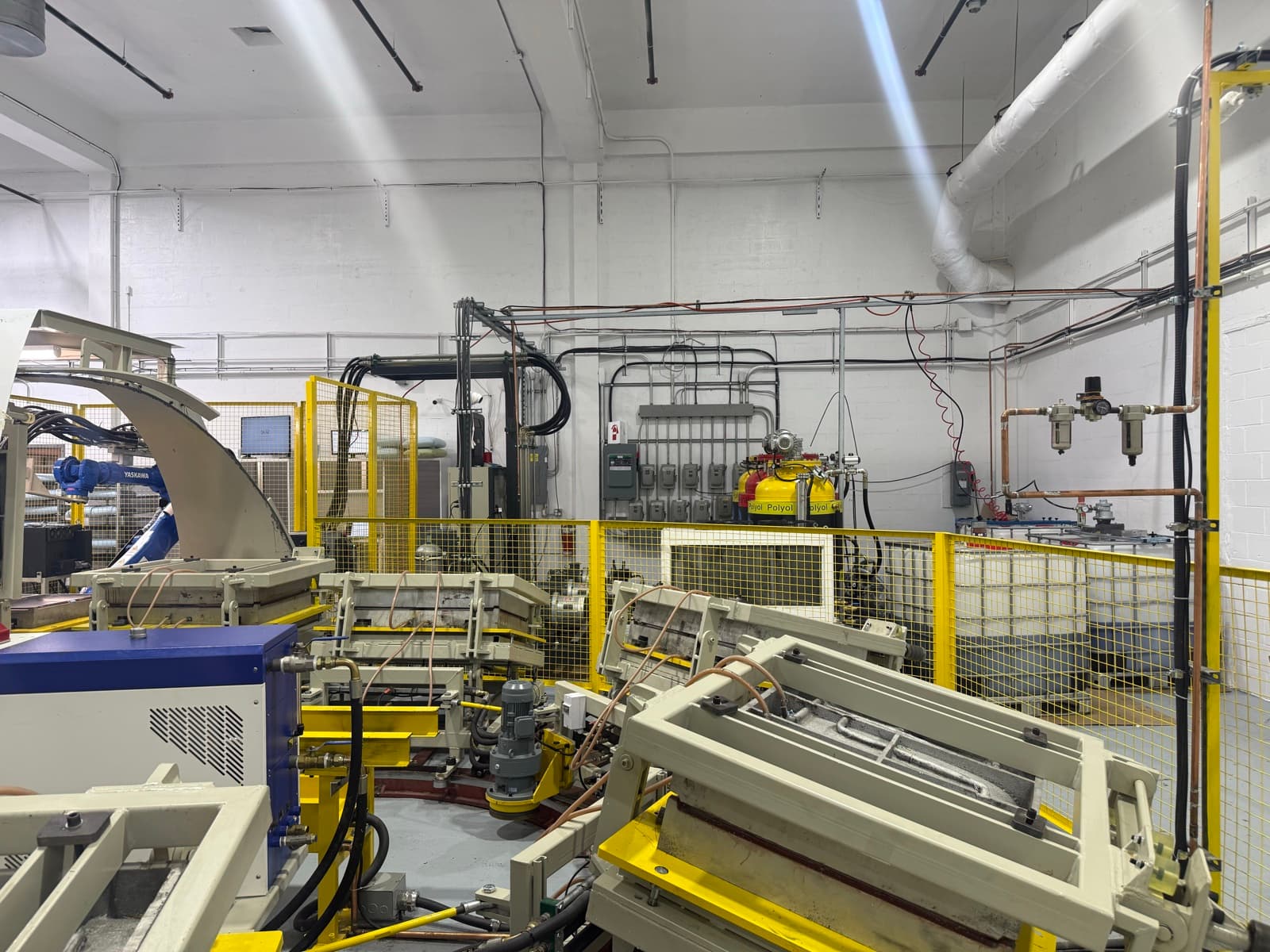 Robotic foam injection molding cell and processing line at the Maple Sleep factory in Quebec.