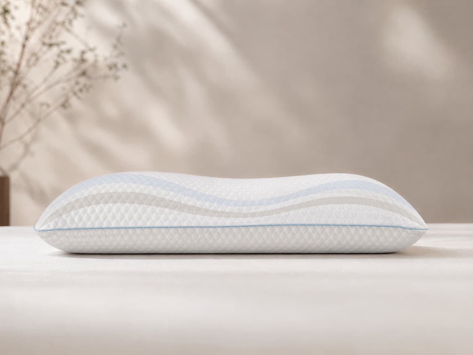 Full side profile of the Maple Sleep pillow showing its height, cover texture, and blue edge piping.